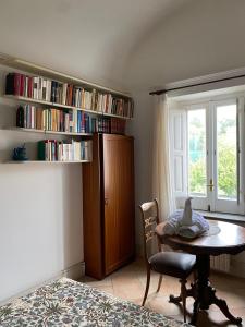 a room with a table and a book shelf with books at Suggestivo appartamento vista mare in palazzo del'400 in Massa Lubrense