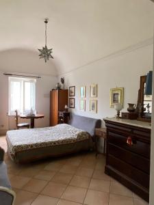 a bedroom with a bed and a table and a window at Suggestivo appartamento vista mare in palazzo del'400 in Massa Lubrense