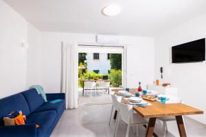a living room with a blue couch and a table at Baia Degli Aranci Suite & Apartments in Vieste