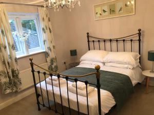 a bedroom with a bed and a window and a chandelier at Cherry Tree house in Wellington
