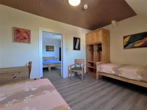a bedroom with two beds and a chair in a room at Familie Hensen - FeWo mit überdachter Terrasse im Ortskern von Tarp in Tarp