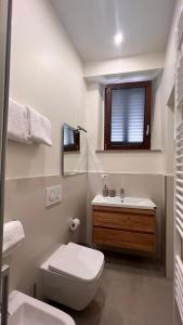 La salle de bains est pourvue de toilettes, d'un lavabo et d'une fenêtre. dans l'établissement B&B Aurora, à Gavinana