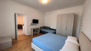 - une chambre avec un lit bleu et un canapé dans l'établissement B&B Aurora, à Gavinana