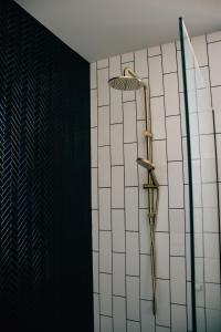 um chuveiro numa casa de banho com azulejos pretos e brancos em Rooms of Renown - The Panaretto Parlour em Leeton