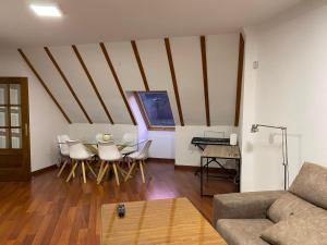 a living room with a couch and a table and chairs at Increible Ático centro Monachil in Monachil