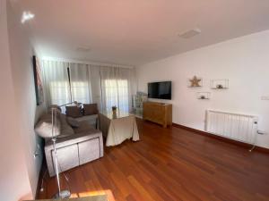 ein Wohnzimmer mit einem Sofa und einem Tisch in der Unterkunft Increible Ático centro Monachil in Monachil