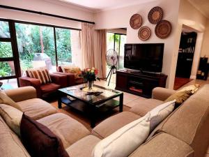 - un salon avec un canapé et une télévision dans l'établissement Villa T3 - Selborne Golf Estate, à Pennington