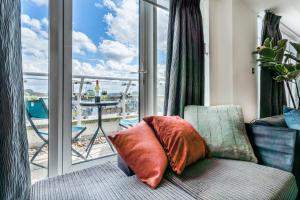 a couch with a pillow in front of a window at London Bridge Penthouse - Luxury in London