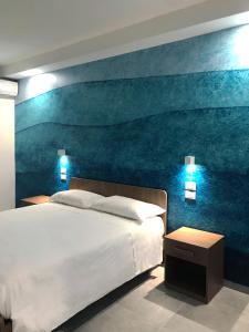 una camera da letto con un grande letto e un dipinto sul muro di Eraora Hotel Village a Battipaglia