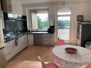 uma cozinha com uma mesa e uma mesa e cadeiras em 2Schlafzimmer, Wohnküche&Balkon em Oberhausen