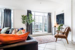 a living room with a couch and a window at London Bridge Penthouse - Luxury in London