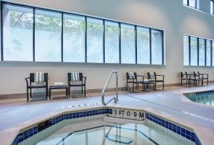 uma piscina com cadeiras, mesas e janelas em Embassy Suites by Hilton Washington D.C. Georgetown em Washington