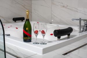 a bottle of wine and two wine glasses on a sink at Nish Suites Beşiktaş in Istanbul