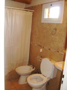 łazienka z toaletą i umywalką w obiekcie Complejo de Cabañas Tierra de Luna w mieście Potrerillos