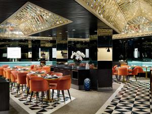 um restaurante com cadeiras e mesas cor de laranja e um bar em Millennium Hilton New York One UN Plaza em Nova Iorque