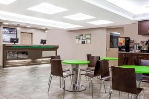 - un bar avec des tables et des chaises vertes dans une pièce dans l'établissement Super 8 by Wyndham Saskatoon Near Saskatoon Airport, à Saskatoon