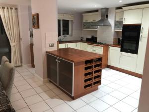 una cocina con armarios blancos y una isla de madera en Cherry Tree house en Wellington