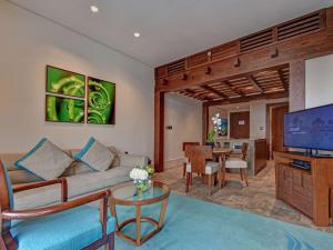 a living room with a couch and a television at Sofitel Dubai Palm Apartments in Dubai