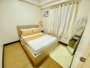 a small bedroom with a bed and a window at 17Eleven Staycation Home in Manila