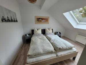 een slaapkamer met een bed met witte lakens en kussens bij Casa-Mandelartz in Rees