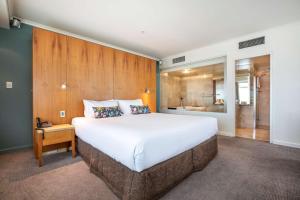 a bedroom with a large bed and a bathroom at Gateway Hotel by Nightcap Plus in Devonport