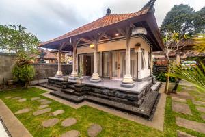 a house with a garden in front of it at Alam Desa Homestay by AGATA in Perean