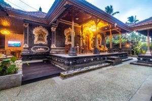 a temple with a large building with benches and tables at Alam Desa Homestay by AGATA in Perean +25 photos