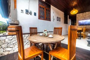 Alam Desa Homestay في Perean: طاولة وكراسي خشبية في الغرفة