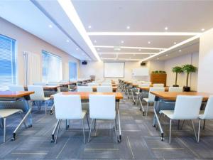 a conference room with tables and chairs and a whiteboard at Ibis Style Beijing Capital Airport in Shunyi