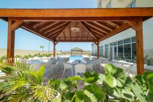 un patio con mesas y sillas en la playa en Wyndham Garden El Morro Montecristi, 
