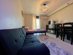 - un salon avec un canapé bleu et une table dans l'établissement Gibzon's Invitation Suites near Mactan airport, à Mactan
