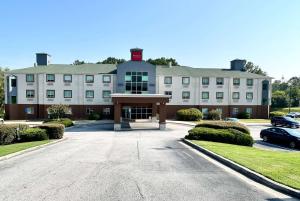a large white building with a parking lot at Ramada by Wyndham Lithia Springs Atlanta in Lithia Springs