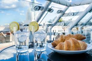 a table with a plate of bread and two glasses of water at London Bridge Penthouse - Luxury in London