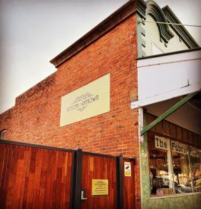 a brick building with a sign on the side of it at Rooms of Renown - The Enterprise Suite in Leeton