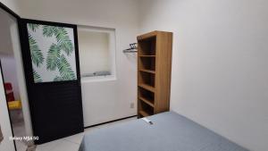 a room with a bed and a black door at CANTINHO DA FELICIDADE in Pau dos Ferros