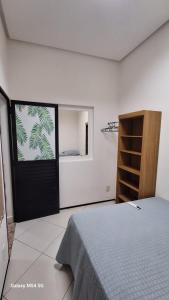 1 dormitorio con 1 cama y puerta con ventana en CANTINHO DA FELICIDADE, en Pau dos Ferros