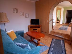 - un salon avec un canapé bleu et une table dans l'établissement Ferienwohnung am Kronhof, à Lychen