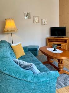 un soggiorno con un divano blu e un tavolo di Ferienwohnung am Kronhof a Lychen Altre 10 foto