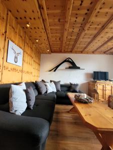 sala de estar con sofá negro y mesa de madera en Winterberg Appartement 21077, en Winterberg