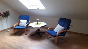 een kamer met 2 stoelen, een tafel en een raam bij Ferienwohnung Tetzlaff in Neubörger