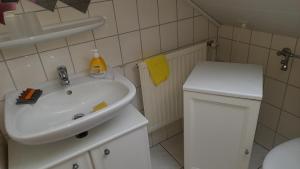 a bathroom with a white sink and a toilet at Ferienwohnung Tetzlaff in Neubörger