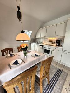 a kitchen with a table with chairs and a kitchen with white cabinets at Winterberg Appartement 21103 in Winterberg