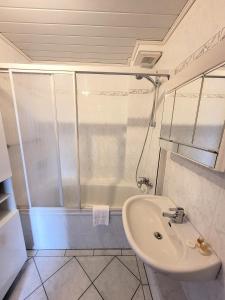 a white bathroom with a sink and a shower at Winterberg Appartement 21109 in Winterberg