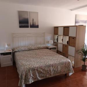a bedroom with a large bed with a bedspread at Apartamento Bambadela in Cala del Moral
