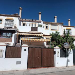 a white house with a wooden gate at Apartamento Bambadela in Cala del Moral