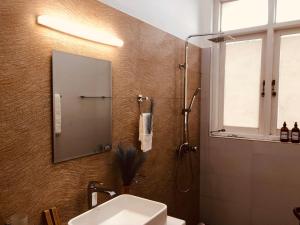 a bathroom with a sink and a shower with a mirror at Ace Boutique Airport in Katunayaka