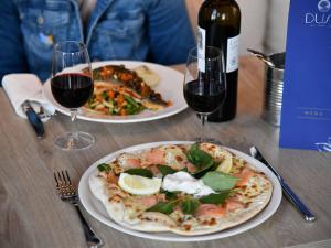 een tafel met twee borden eten en twee glazen wijn bij ibis budget Saint Nazaire Centre Gare in Saint-Nazaire