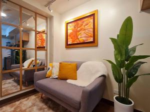 a living room with a couch and a plant at Prisma Residences - Celeste in Manila