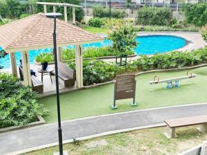 a park with a swimming pool and a bench and a sign at Prisma Residences - Celeste in Manila