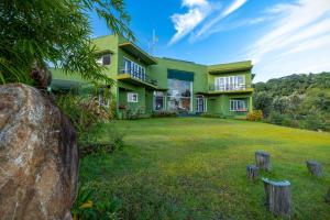 ama Stays & Trails Anjanagiri , Kotagiri في كوتاغيري: منزل أخضر أمامه ساحة